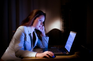 Underpaid woman at desk in Chino Hills working overtime.